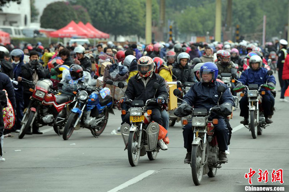 A photo taken on Jan 27 2011 in Zhaoqing City, Guangdon Province shows a group of migrant workers ride motorcycles back to their hometown for Spring Festival. [Photo/Chinanews.com]